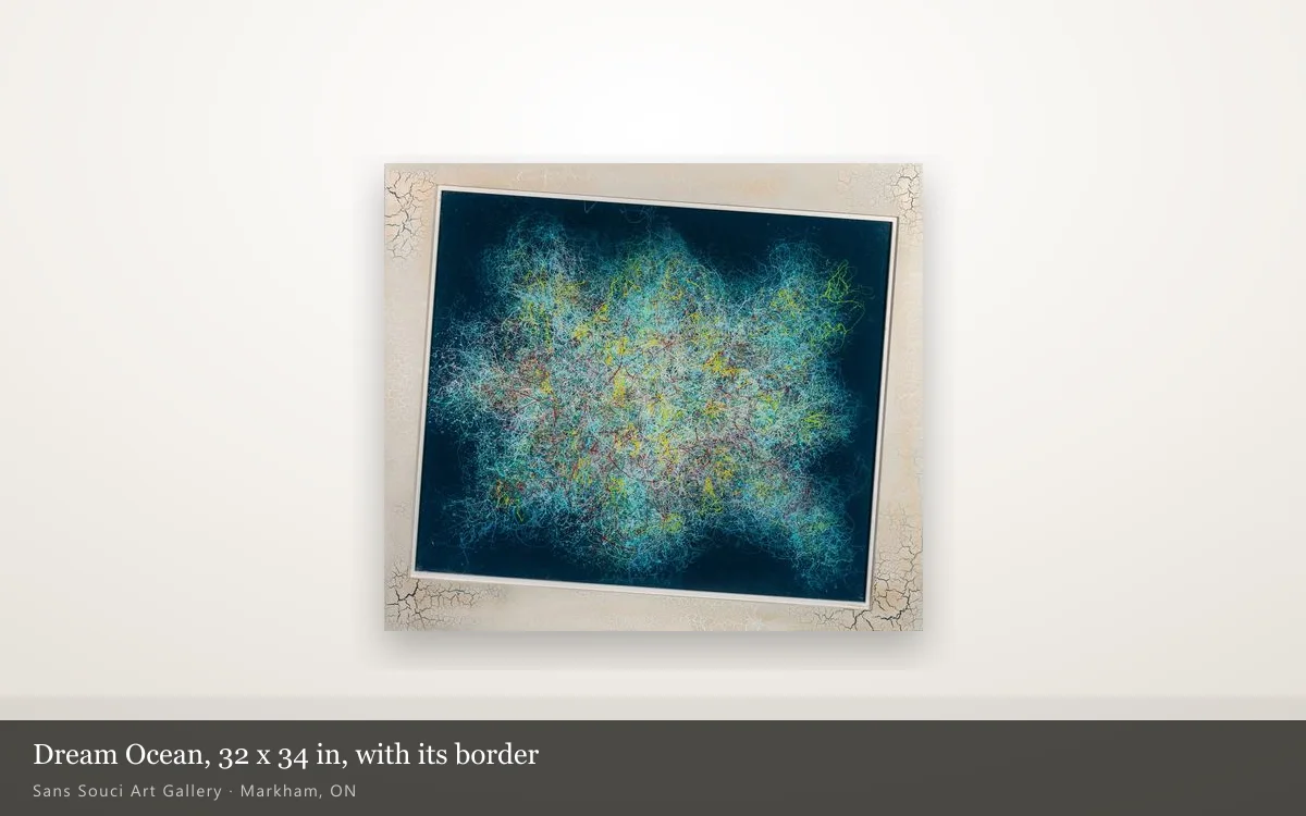 Dream Ocean shown whole on a pale wall: a navy field with a cloud of turquoise, yellow and red threads inside a wide cream border whose cracks gather at the four corners